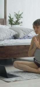 woman practicing yoga at computer